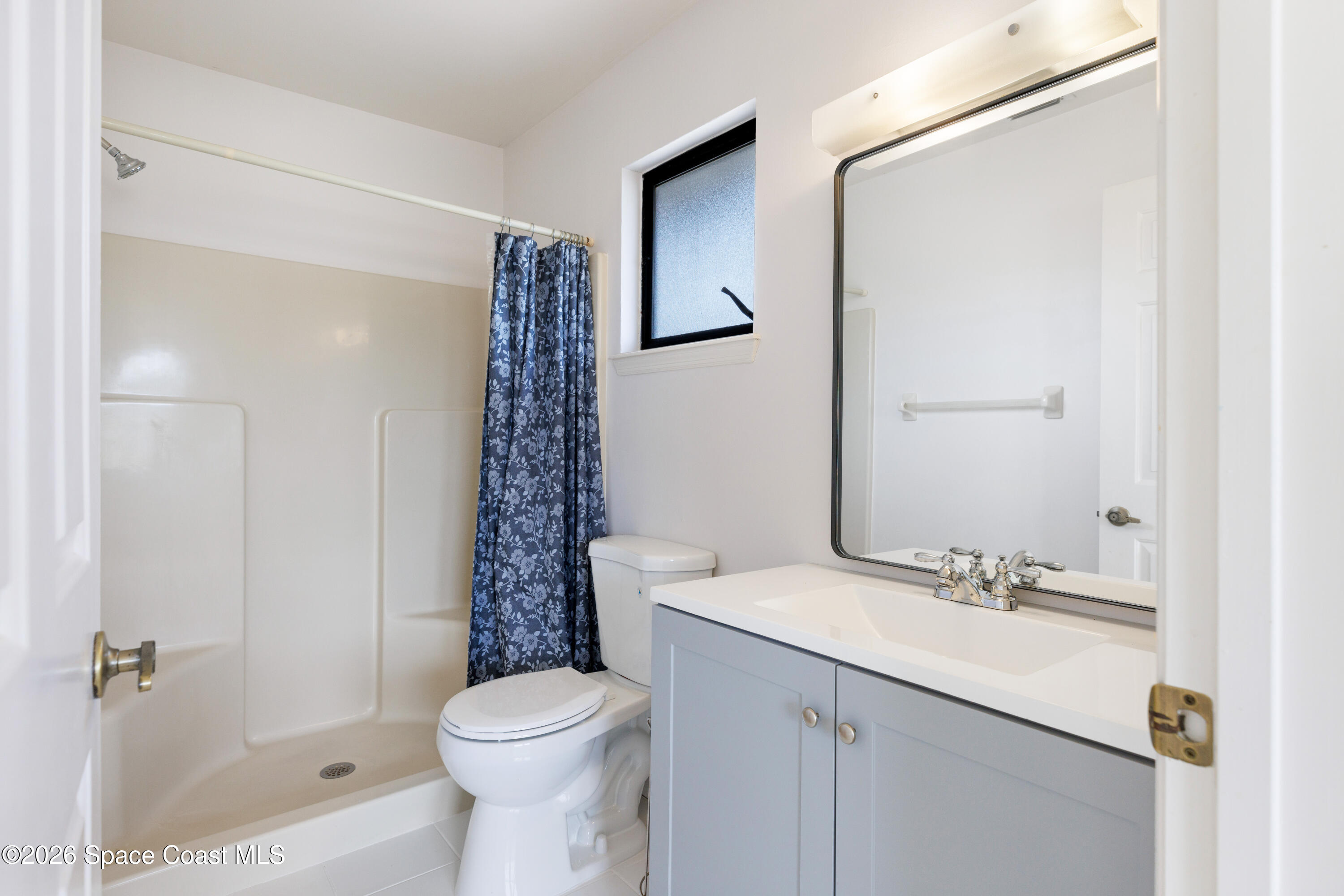 654 Centre Court Southwest, Unit 201 Vero Beach, FL 32962 - Photo 9 of 20 a bathroom with a sink a toilet and shower
