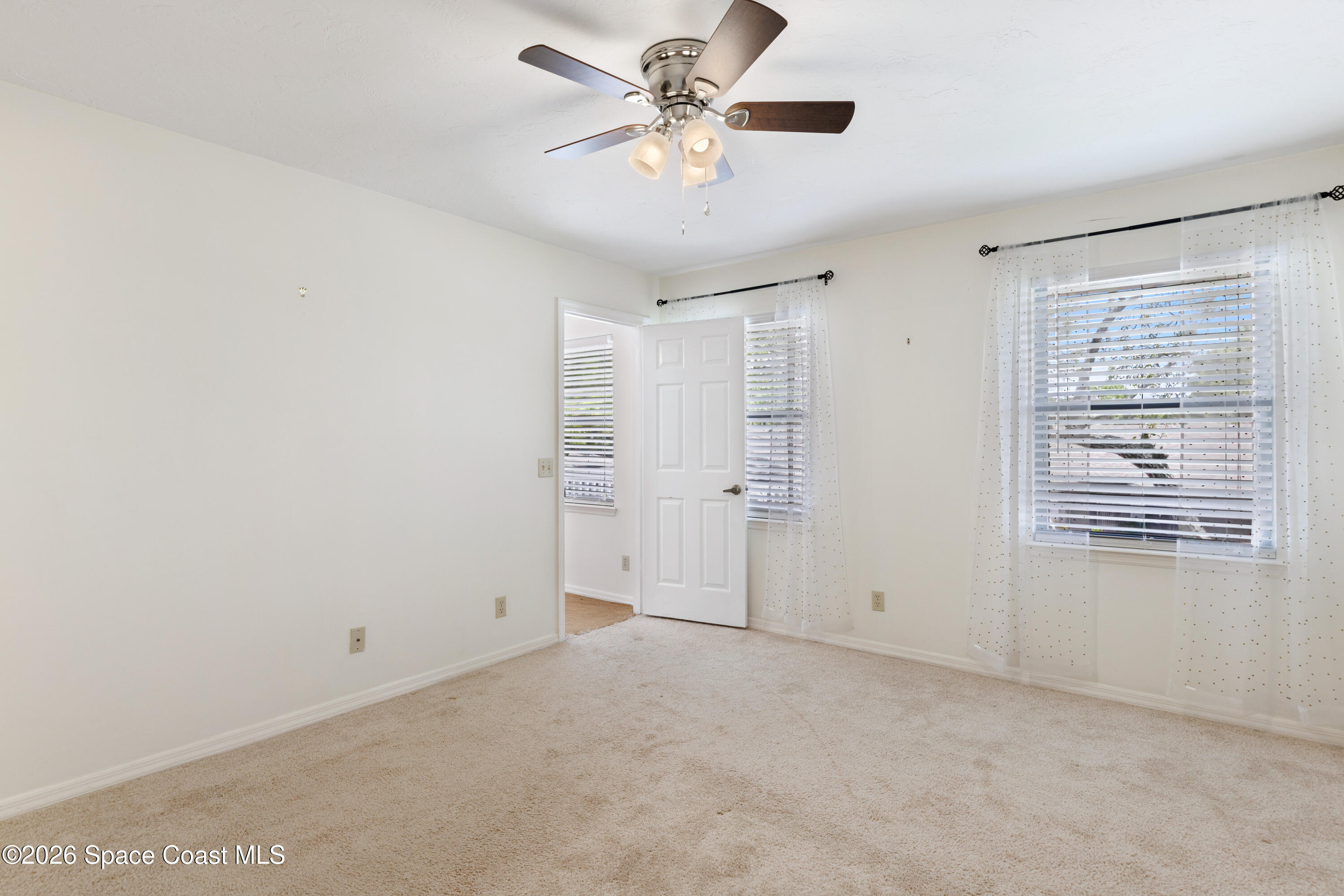 654 Centre Court Southwest, Unit 201 Vero Beach, FL 32962 - Photo 10 of 20 a view of a livingroom with a ceiling fan and window