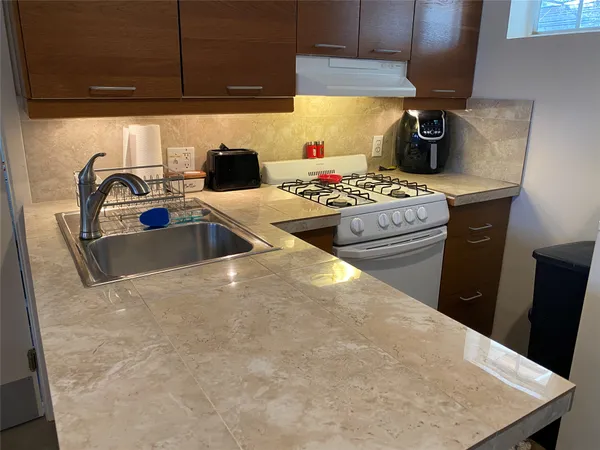 a kitchen with stainless steel appliances a sink a stove top oven a counter space and cabinets