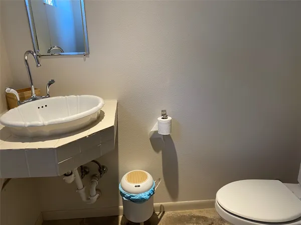 a bathroom with a sink a toilet and a mirror