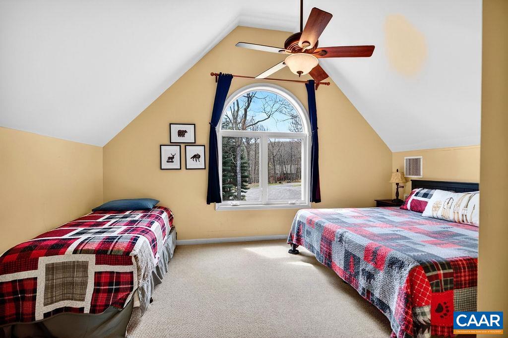 42 Peavy Point Wintergreen, VA 22967 - Photo 38 of 74 a bedroom with a bed a mirror on the dresser and a chandelier