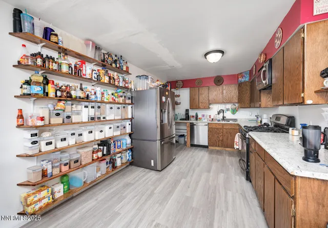 a kitchen with stainless steel appliances granite countertop a refrigerator and a wooden floors