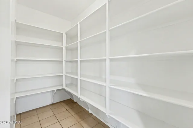 a view of wooden floor and a chandelier fan in a room