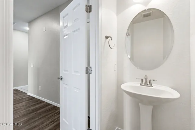 a bathroom with a sink a toilet a mirror and shower