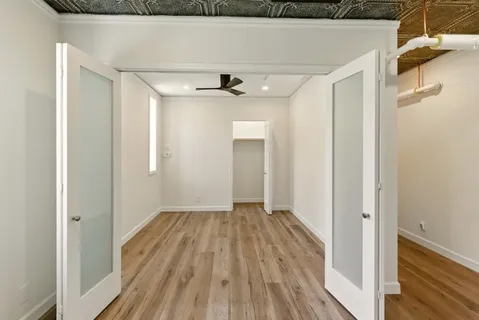 a view of a big room with wooden floor and entryway