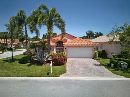 front view of house with a yard and potted plants
