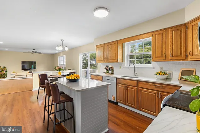 a kitchen with stainless steel appliances a stove a sink dishwasher and a refrigerator with wooden cabinets