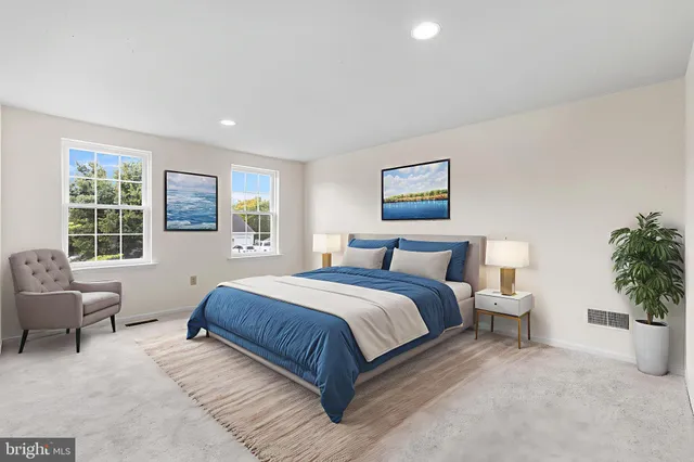 a spacious bedroom with a large bed and a potted plant