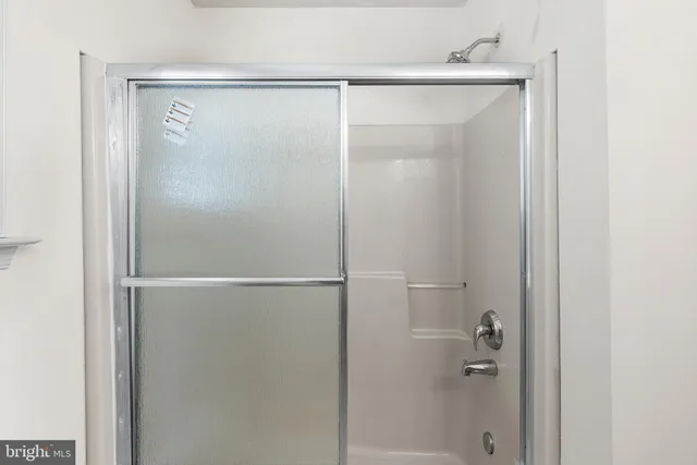 a bedroom with a bed and a window with chair