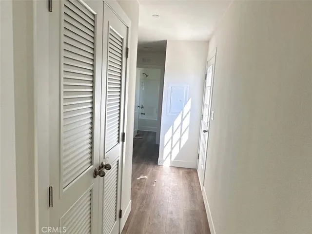 a view of a hallway with wooden floor and staircase