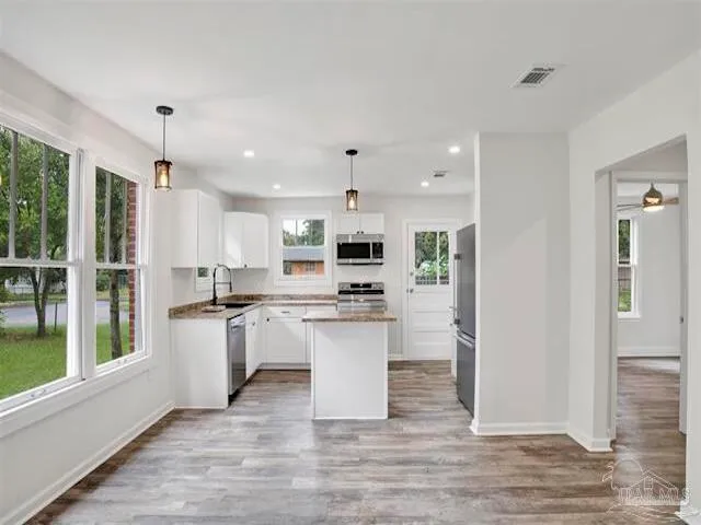 a kitchen with a refrigerator and a wooden floor