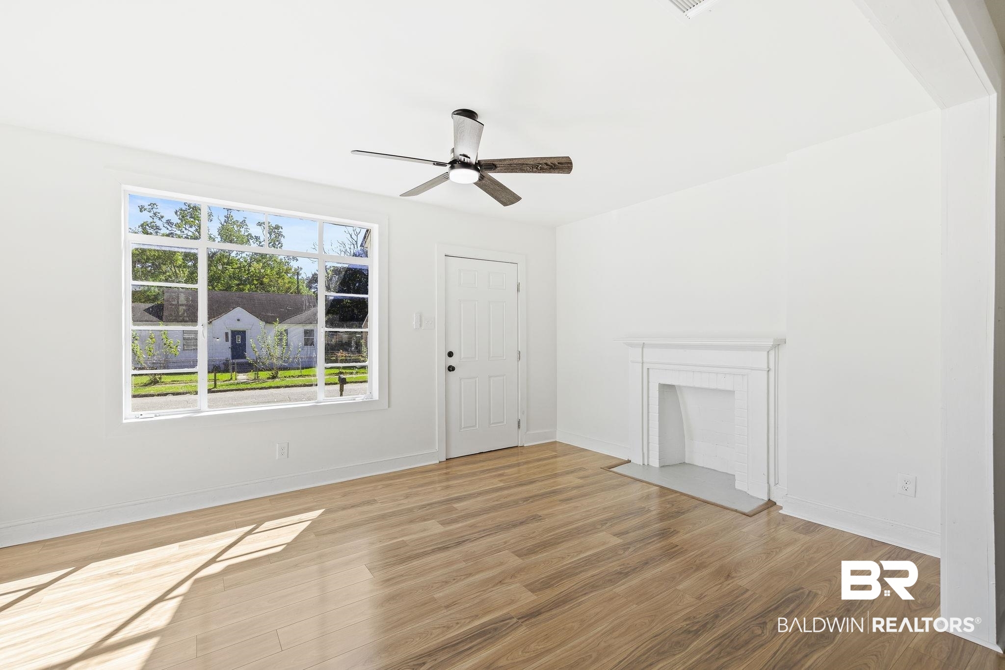 1400 North Cloverleaf Circle Mobile, AL 36605 - Photo 7 of 17 Unfurnished living room with hardwood / wood-style flooring and ceiling fan