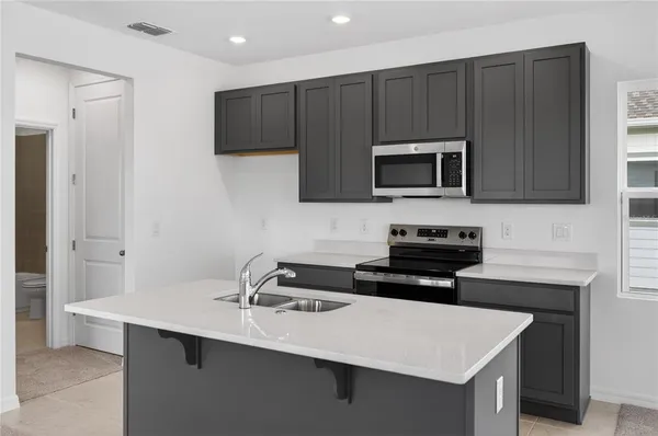 a kitchen with a sink a microwave and cabinets