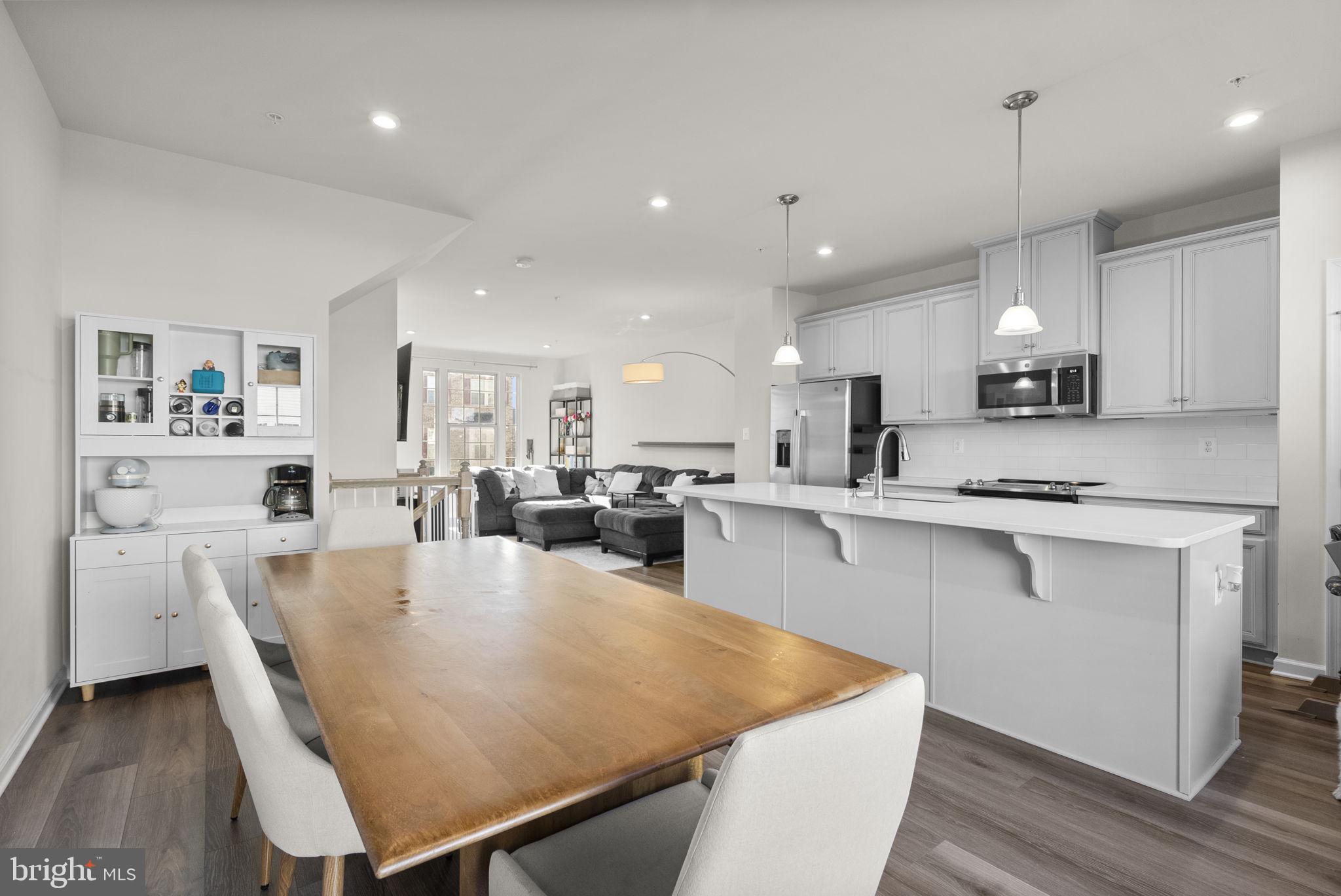7911 Mine Run Road Hanover, MD 21076 - Photo 12 of 49 a large white kitchen with lots of counter space wooden floor and appliances