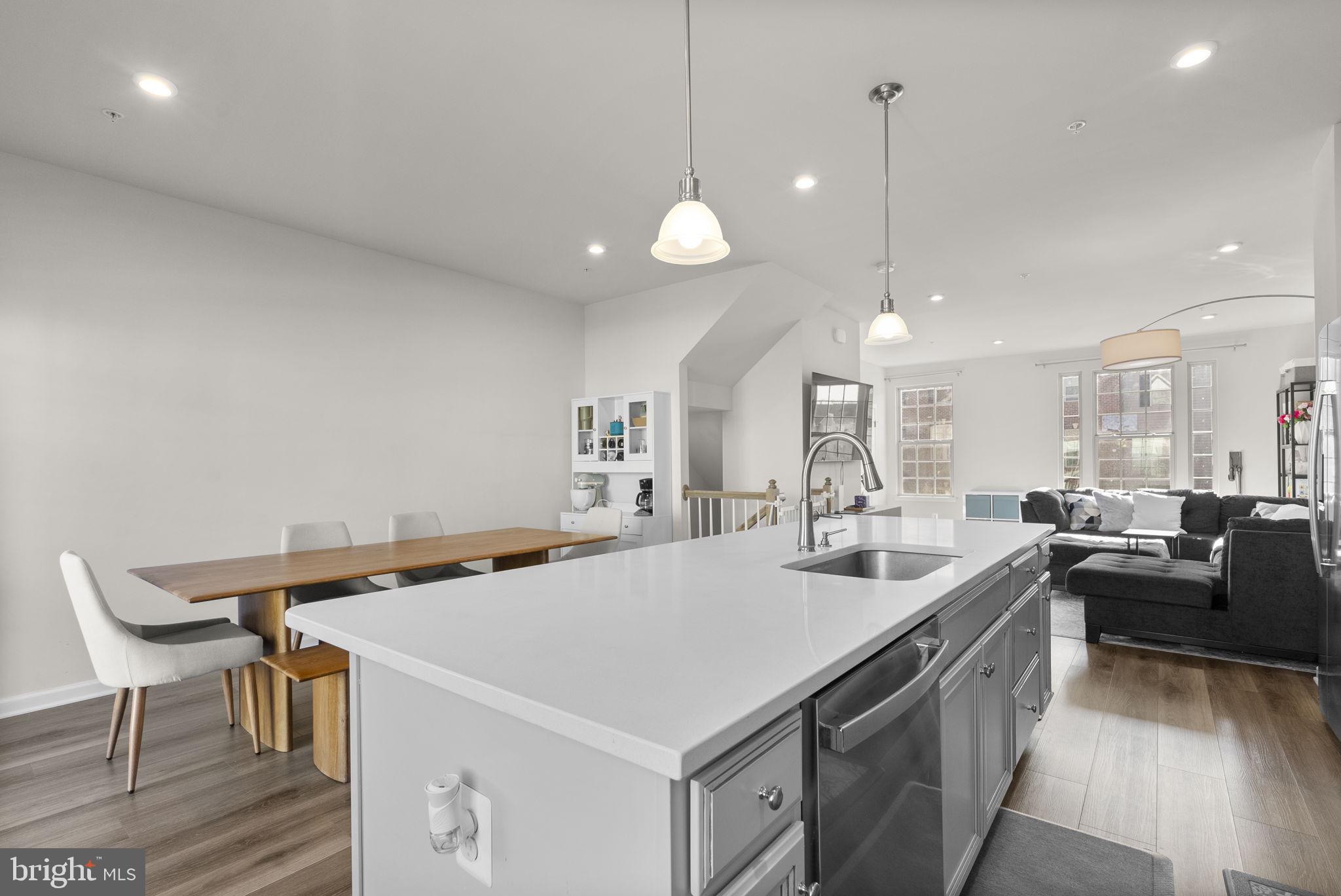 7911 Mine Run Road Hanover, MD 21076 - Photo 15 of 49 a kitchen with a stove a refrigerator a sink dishwasher with a dining table and chairs with wooden floor