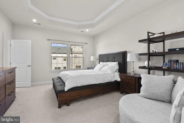 a spacious bedroom with a bed a couch and a window