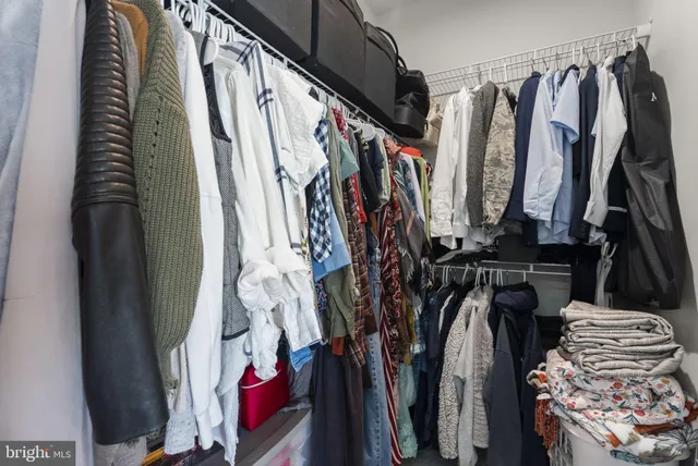 a view of walk in closet with clothes