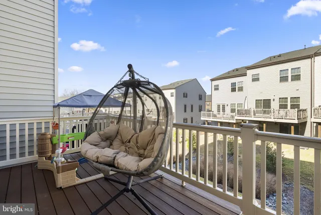 a balcony with wooden floor table and chairs