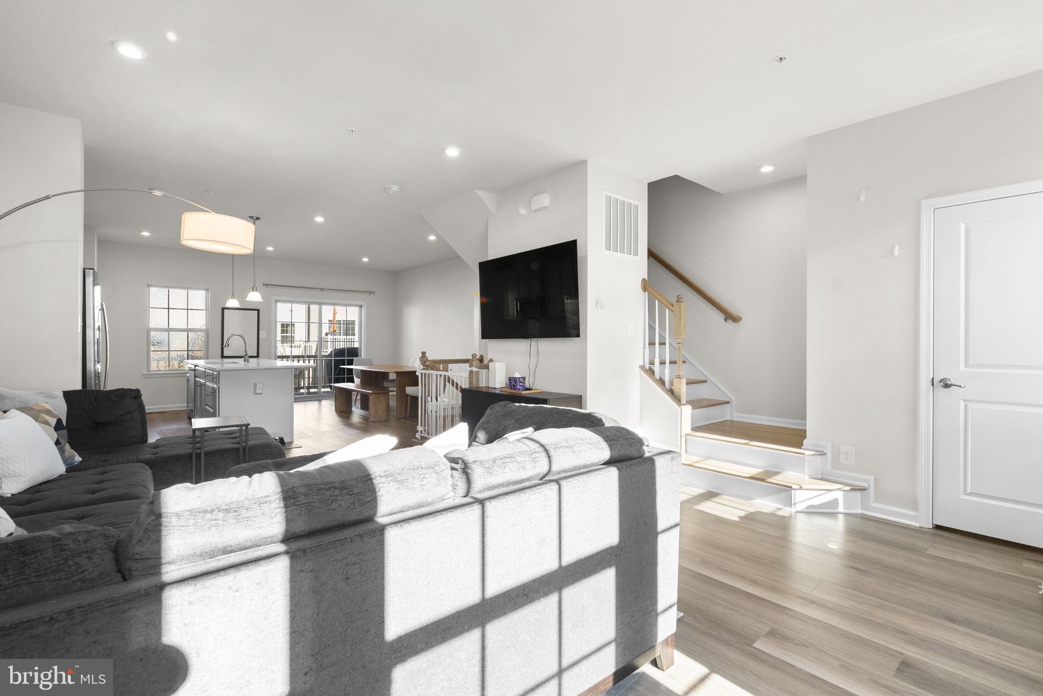7911 Mine Run Road Hanover, MD 21076 - Photo 9 of 49 a living room with furniture a flat screen tv and wooden floor