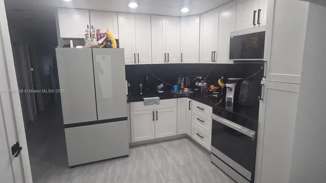a kitchen with stainless steel appliances a refrigerator and cabinets
