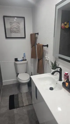 a white toilet sitting next to a bathroom sink