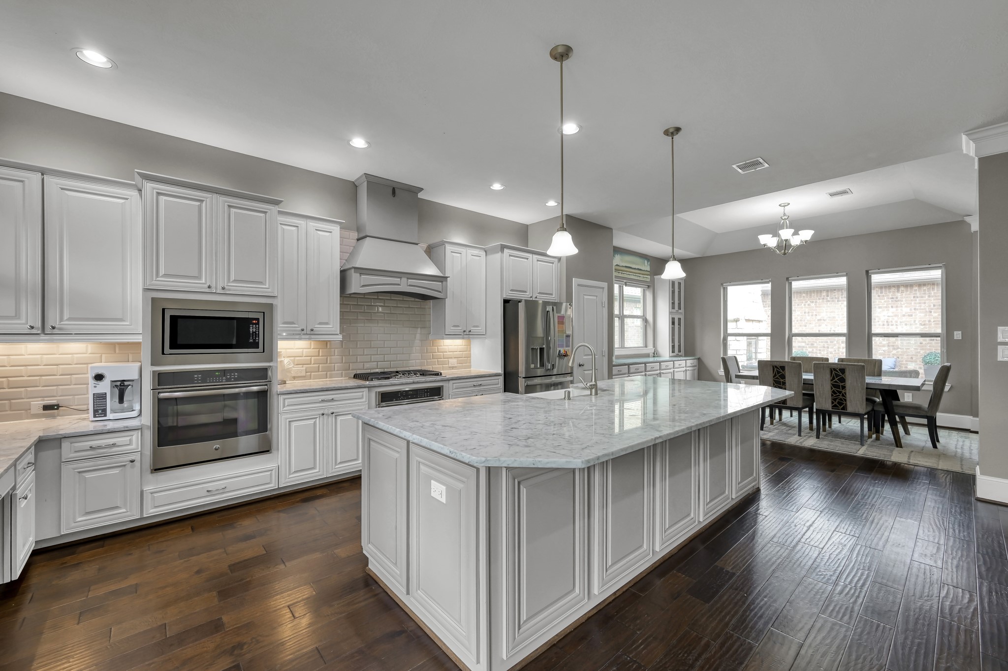 31714 Pierwood Court Spring, TX 77386 - Photo 18 of 49 a kitchen with stainless steel appliances granite countertop a stove top oven a sink dishwasher a dining table and chairs with wooden floor