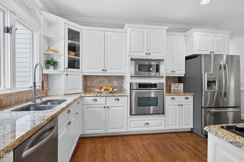 a kitchen with stainless steel appliances granite countertop a stove a sink and a microwave