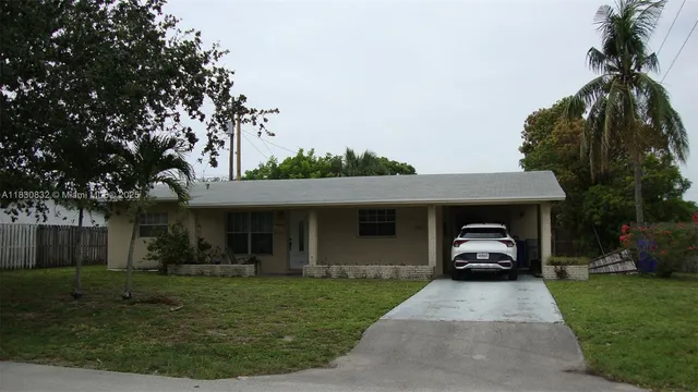 a car parked in front of a house with a garden