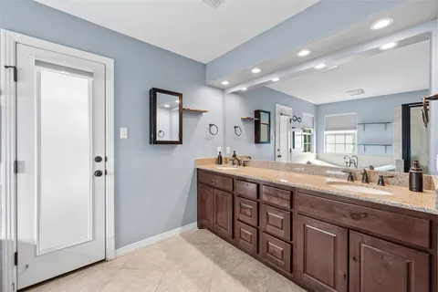 a spacious bathroom with a double vanity sink and a mirror