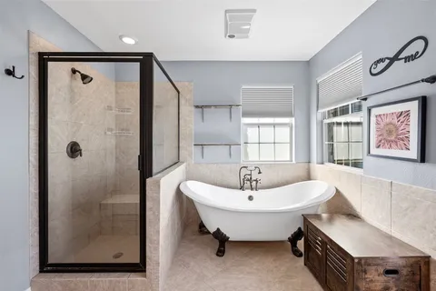 a spacious bathroom with a tub sink and mirror