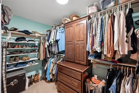 a view of walk in closet with clothes and shoes