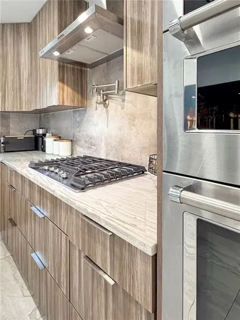 a large kitchen with a large counter top stainless steel appliances and cabinets