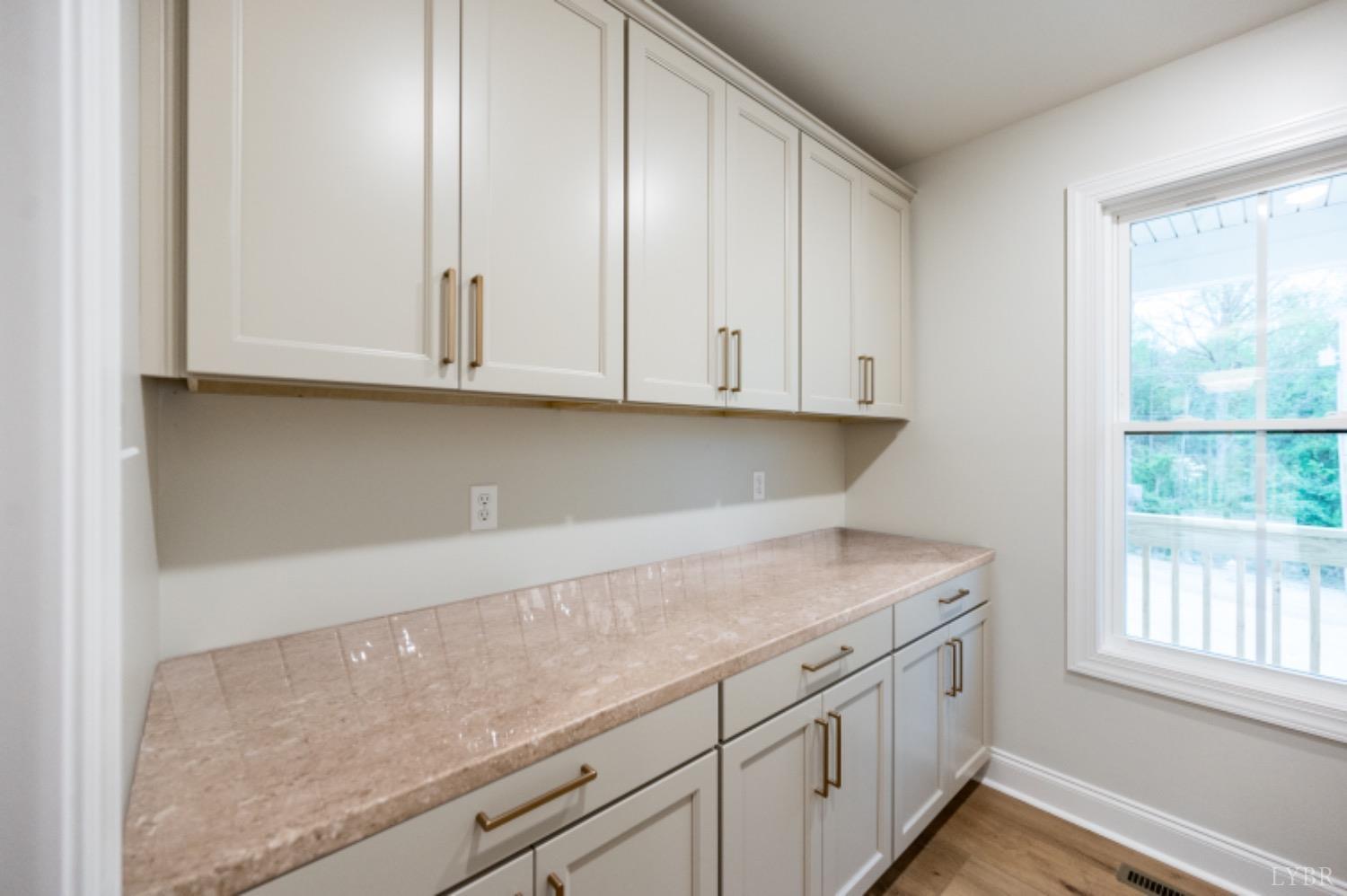 240 Ned Brown Road Amherst, VA 24521 - Photo 19 of 59 a kitchen with granite countertop white cabinets and a window