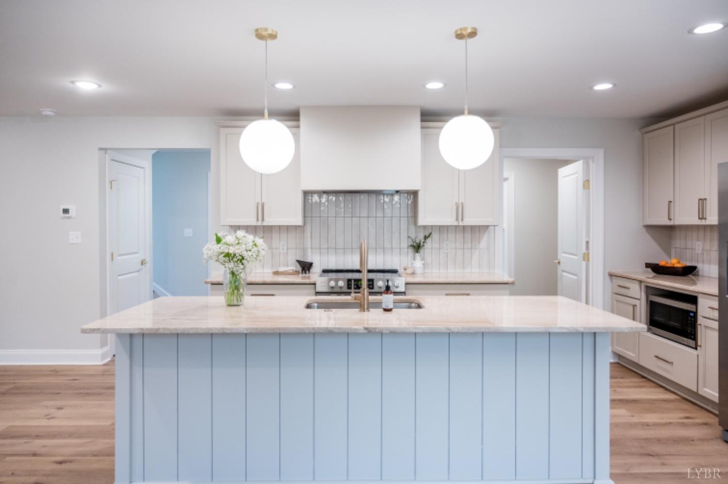 240 Ned Brown Road Amherst, VA 24521 - Photo 24 of 59 a kitchen with kitchen island granite countertop a sink cabinets and wooden floor