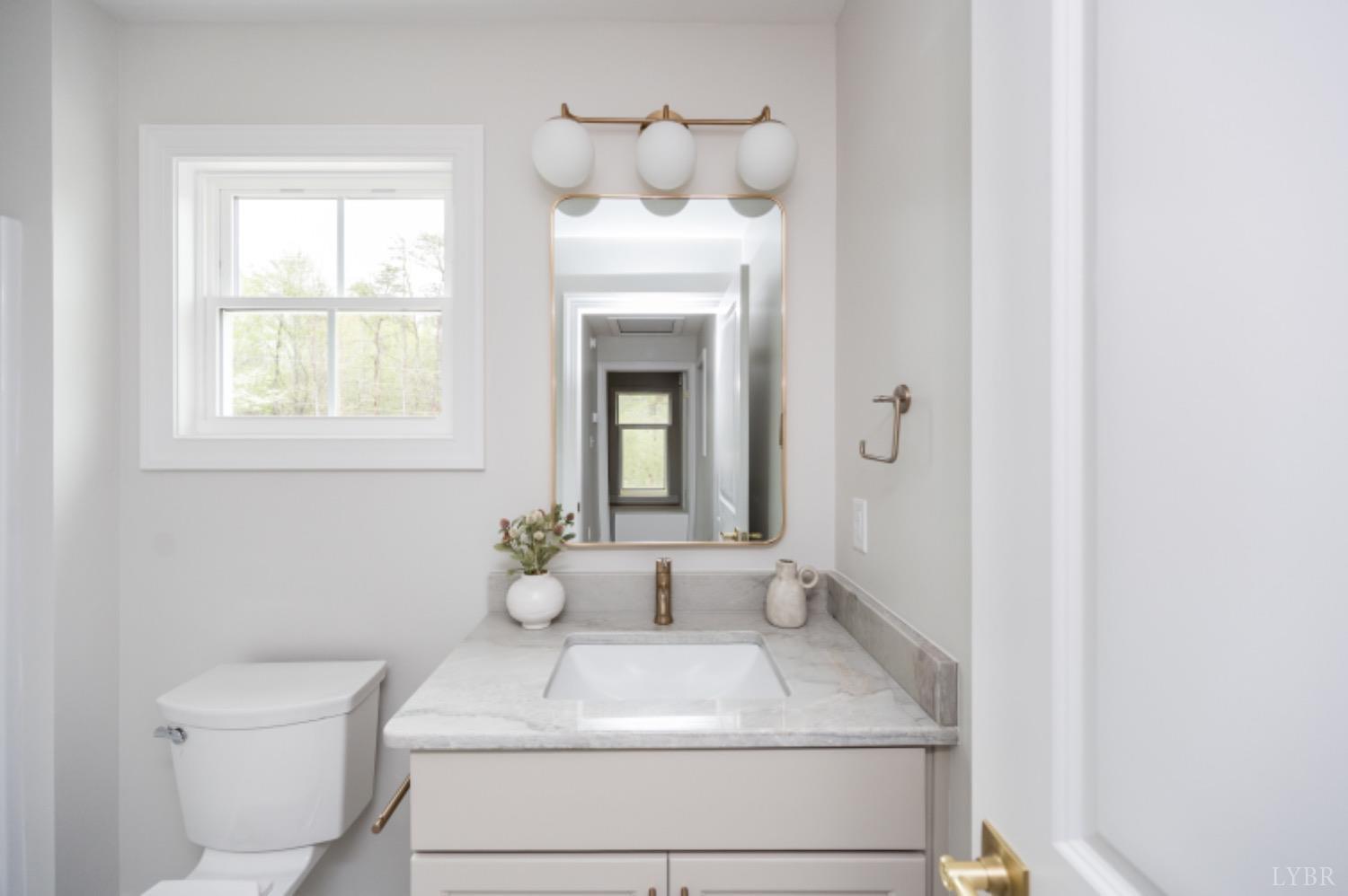 240 Ned Brown Road Amherst, VA 24521 - Photo 31 of 59 a bathroom with a toilet sink and mirror