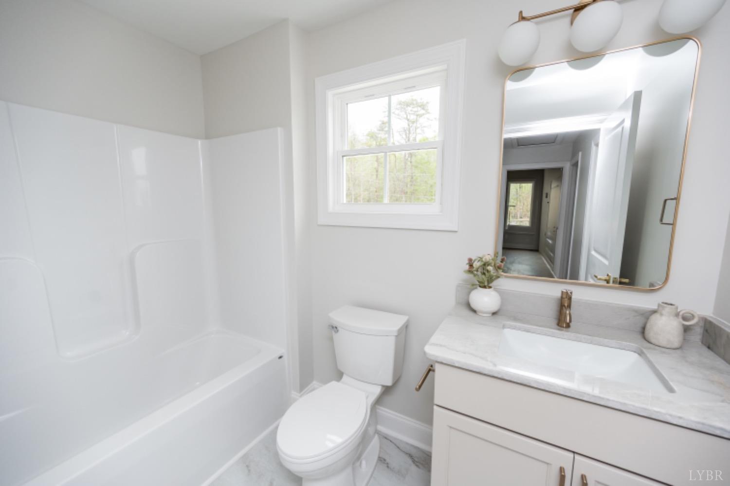 240 Ned Brown Road Amherst, VA 24521 - Photo 32 of 59 a bathroom with a granite countertop toilet a sink and a bathtub