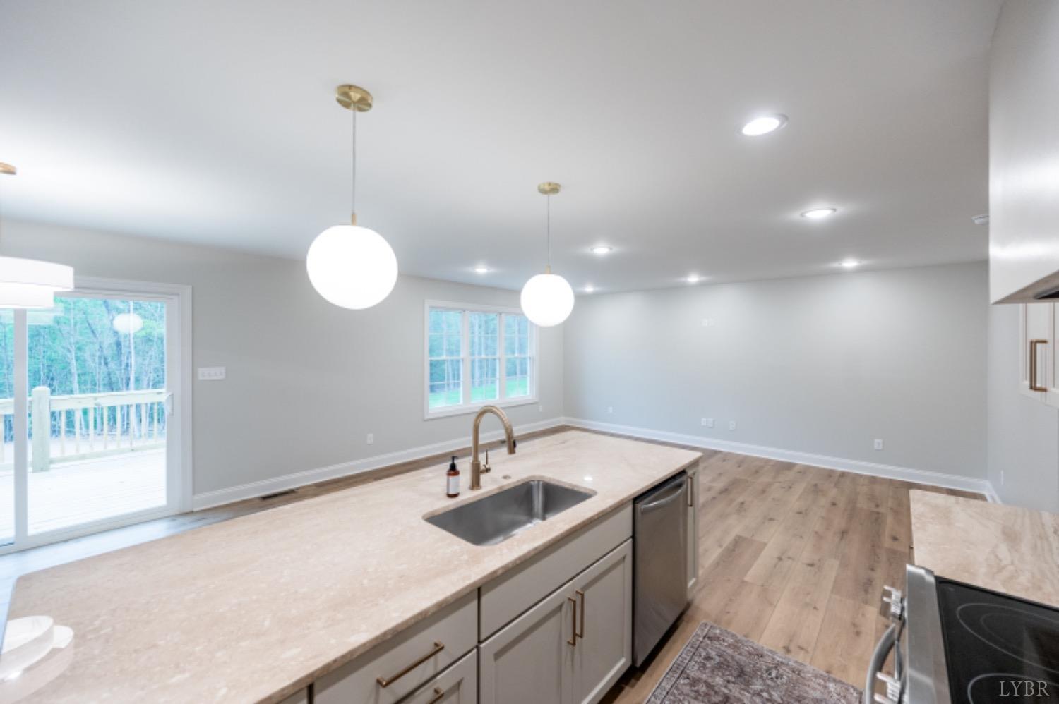240 Ned Brown Road Amherst, VA 24521 - Photo 6 of 59 a kitchen with a sink dishwasher and white cabinets with wooden floor