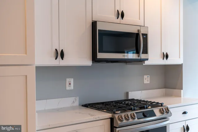 a kitchen with a stove and white cabinets