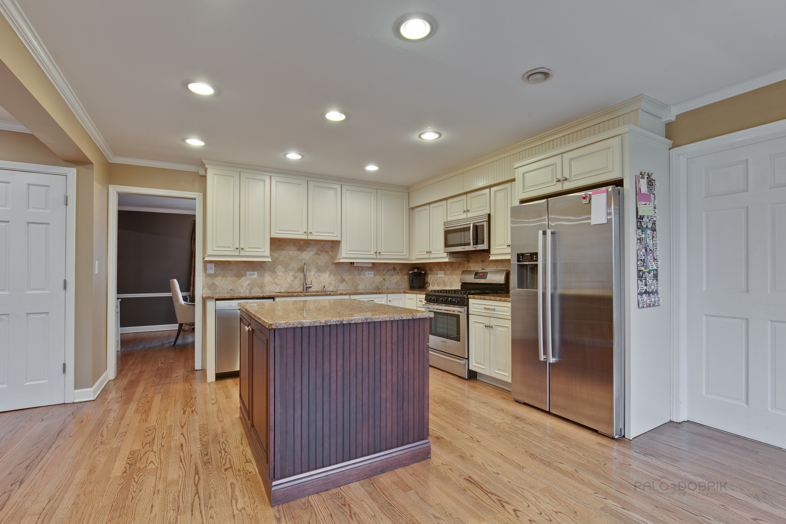 1040 Forest Hill Road Lake Forest, IL 60045 - Photo 11 of 30 a kitchen with kitchen island granite countertop wooden floors stainless steel appliances a sink and a refrigerator