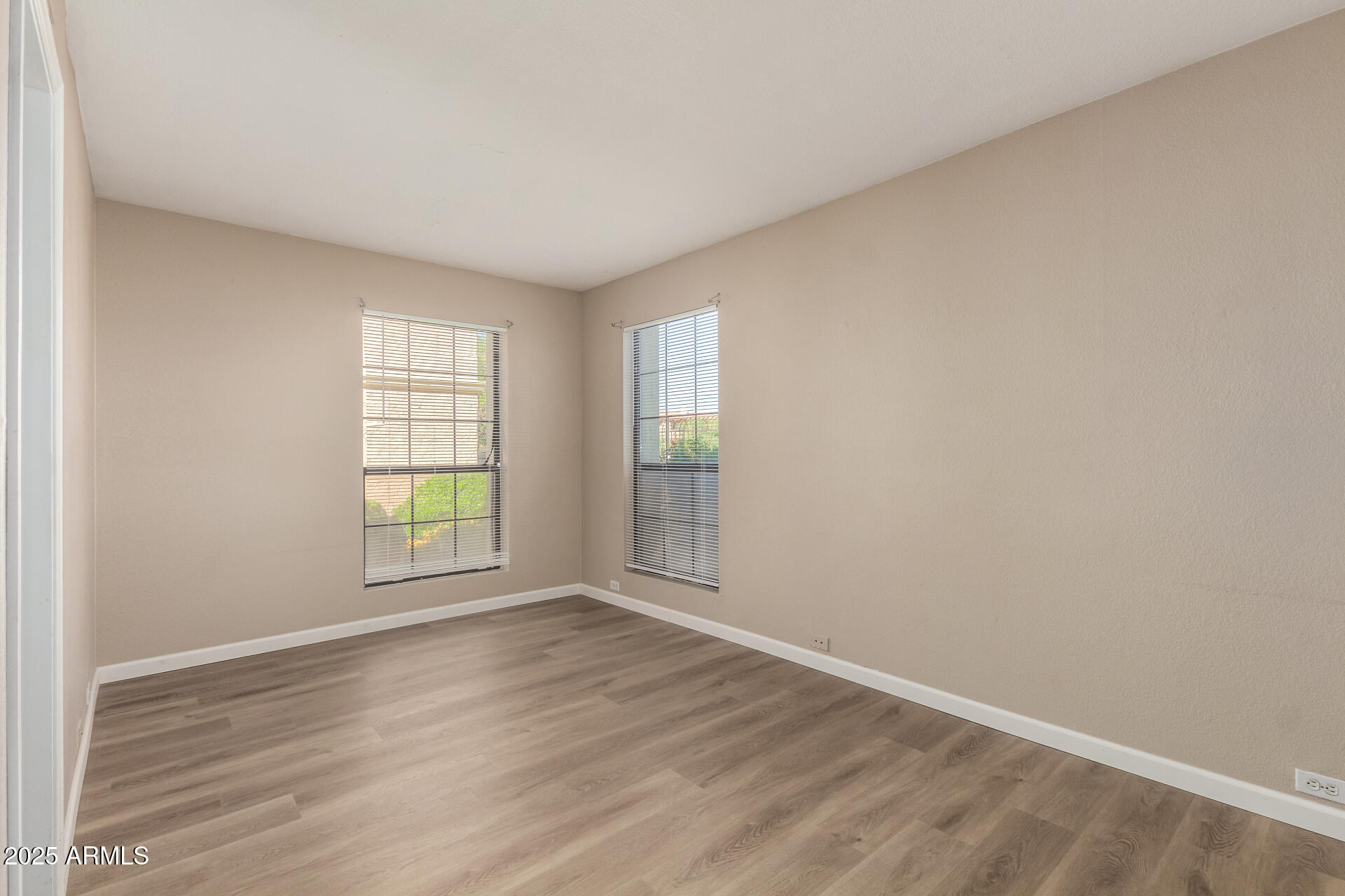 10410 North Cave Creek Road, Unit 1011 Phoenix, AZ 85020 - Photo 32 of 41 an empty room with wooden floor and windows