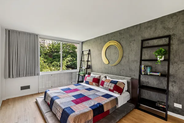 a bedroom with a bed a mirror and window