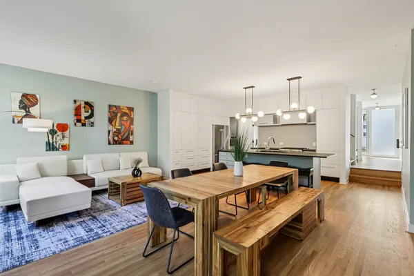a living room with furniture a flat screen tv and kitchen view