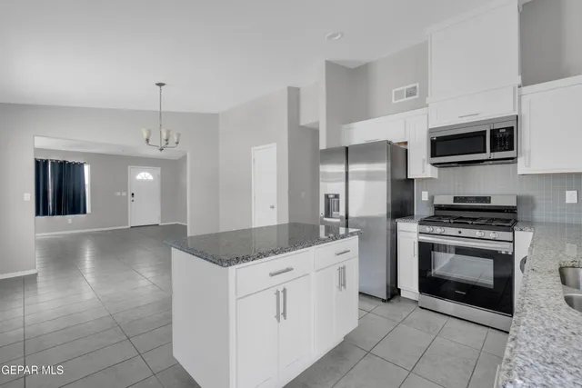a kitchen with stainless steel appliances granite countertop a sink and a stove