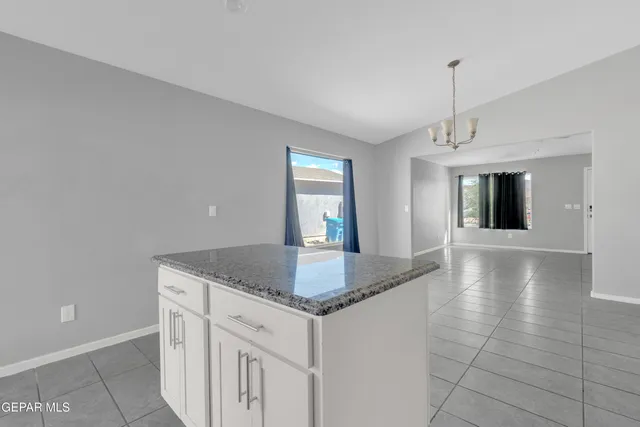 a kitchen with granite countertop a sink and chandelier