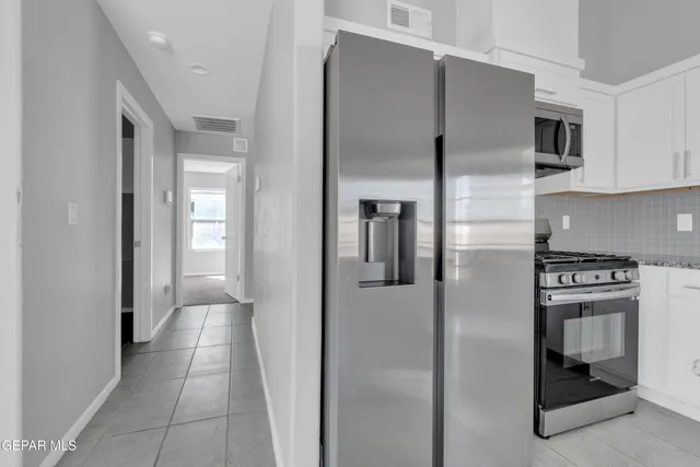 a kitchen with stainless steel appliances granite countertop a refrigerator and a stove