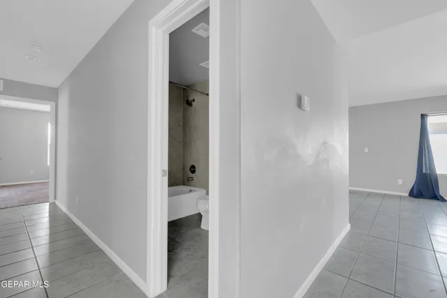 a view of a hallway with a room and a bathroom