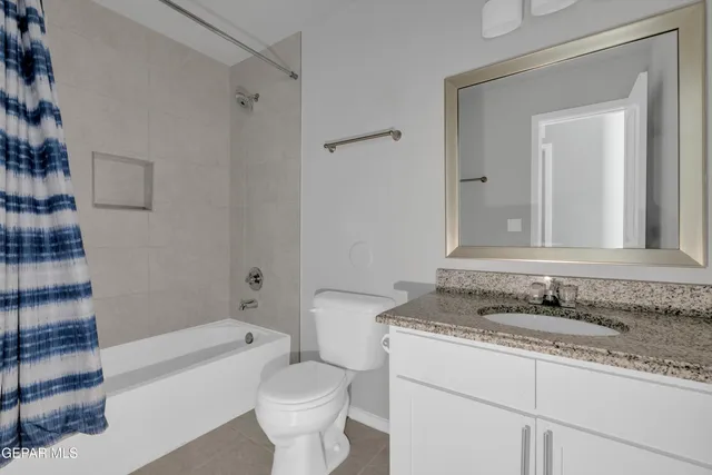 a bathroom with a granite countertop sink toilet mirror and bathtub