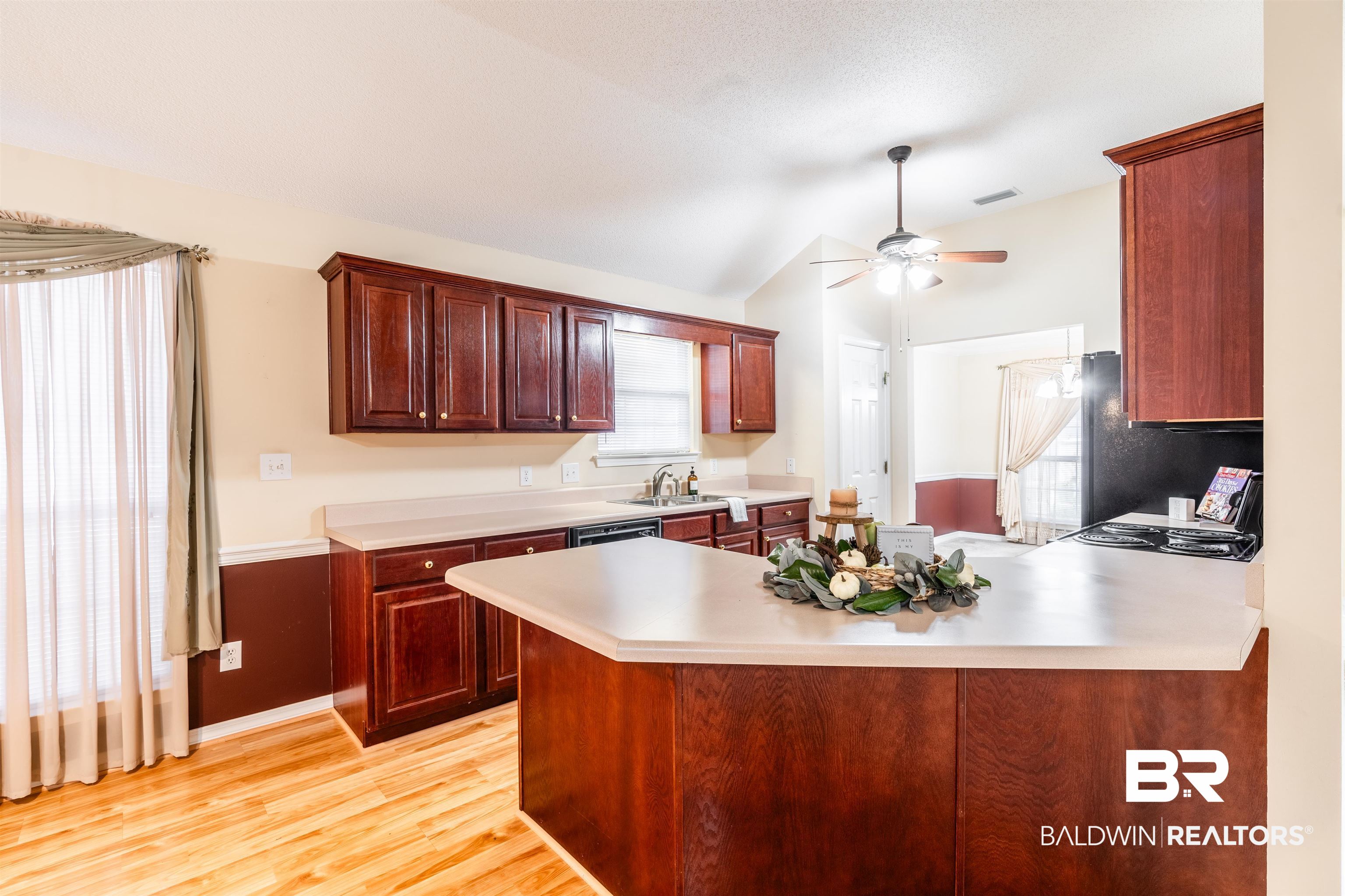 1784 Harrington Way Mobile, AL 36695 - Photo 5 of 18 Kitchen featuring ceiling fan, lofted ceiling, kitchen peninsula, and a healthy amount of sunlight