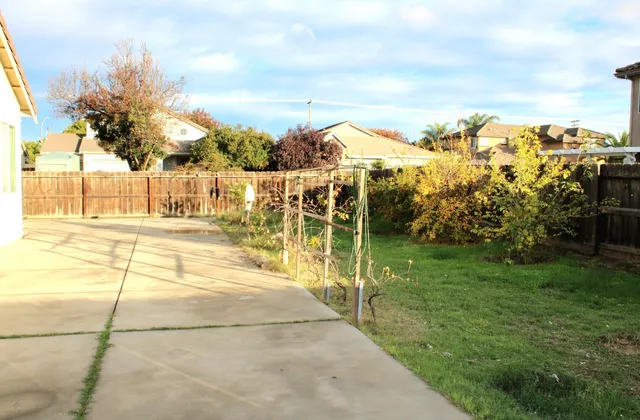 a view of house with a yard and potted plants