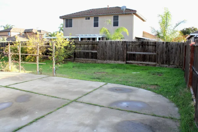 a white house that has tree in front of it